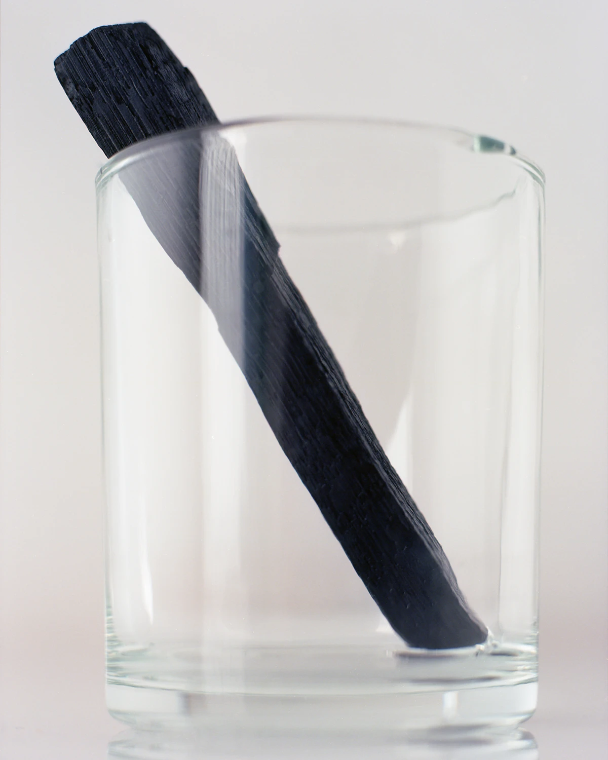 charcoal stick in an empty transparent glass.